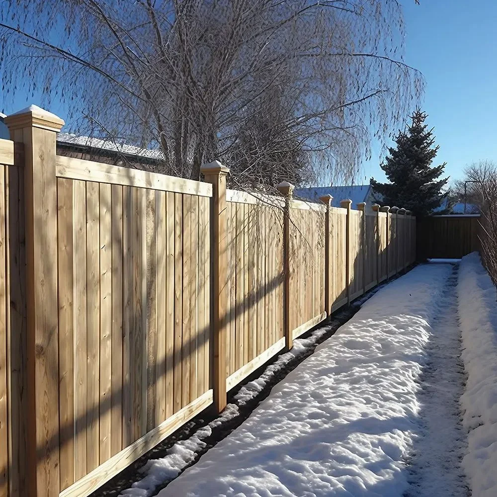 Ash wood privacy fence lining a snowy backyard pathway in winter