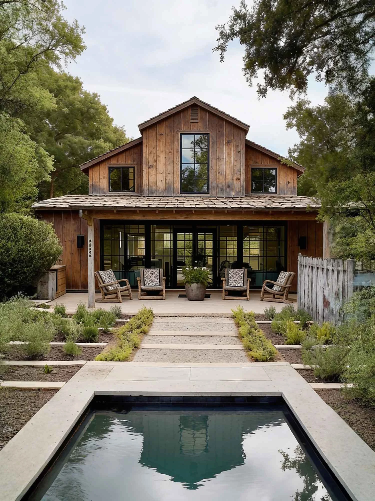 Modern rustic farmhouse with white exterior, landscaped garden, and rectangular pool