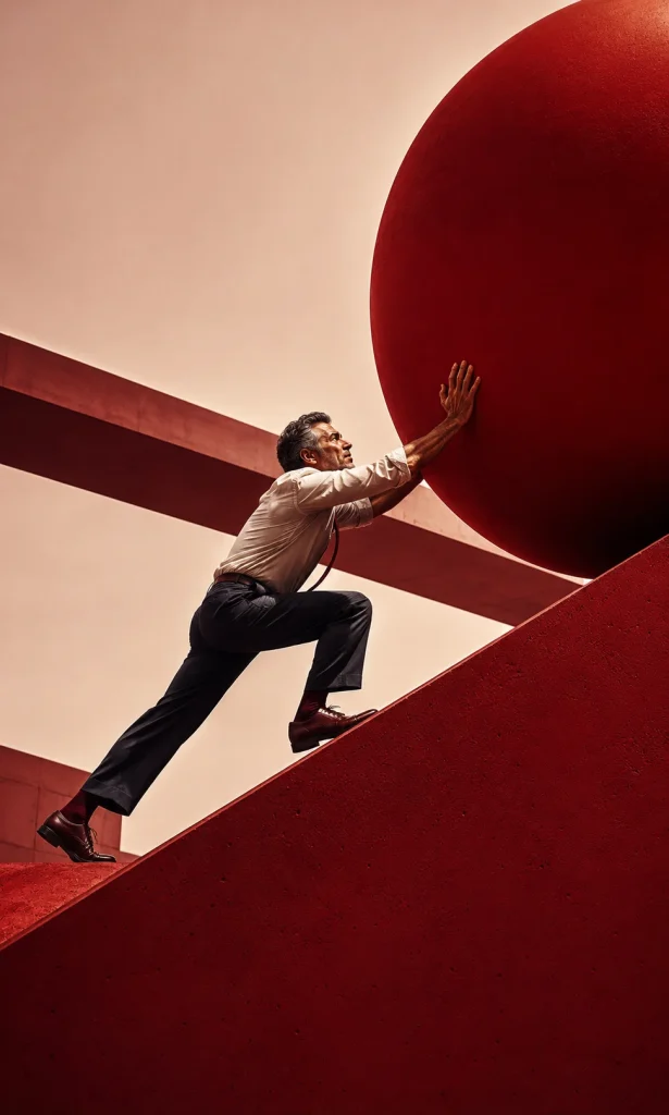 Man pushing a giant debt sphere uphill to show why a lower student loan rate may not mean a lower total cost