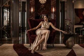 Modern Neo Deco interior with centered fashion model surrounded by dark walnut, red marble, velvet and polished metal