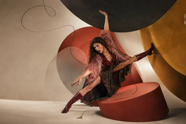 Woman dramatically reaching for a tiny dropped key while enormous abstract circles surround her, representing why small problems can feel overwhelming.