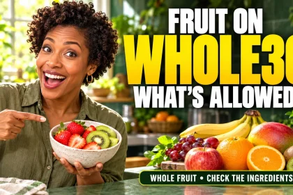 Woman holding strawberries and kiwi beside a selection of fresh fruit